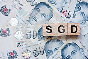 SGD wooden cube on fifty Singapore Dollars banknote background. business, investment, retirement planning, finance and Saving for