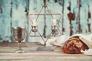 Shabbat candles in glass candlesticks Blurred challah bread