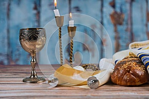 Shabbat eve table candles and cup of wine with covered challah bread