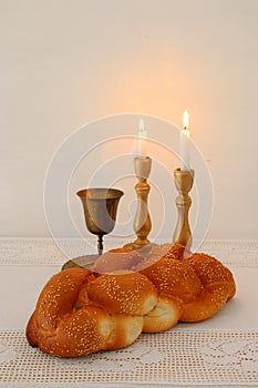 shabbat image. challah bread, shabbat wine and candles on the table.