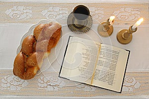 shabbat image. challah bread, shabbat wine and candles on the table. Top view.