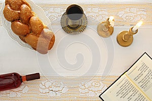 shabbat image. challah bread, shabbat wine and candles on the table. Top view.