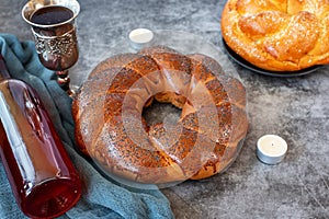 Shabbat Shalom - challah bread, shabbat wine and candles on grey background. With copy space