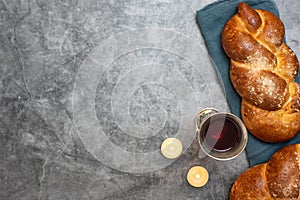 Shabbat Shalom - challah bread, shabbat wine and candles on grey background. Top view. With copy space