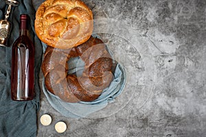 Shabbat Shalom - challah bread, shabbat wine and candles on grey background. Top view. With copy space