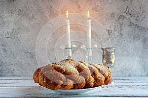 Shabbat Shalom - challah bread, shabbat wine and candles on wooden table