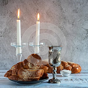 Shabbat Shalom - challah bread, shabbat wine and candles on wooden table