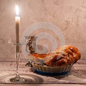 Shabbat Shalom - challah bread, shabbat wine and candles on wooden table