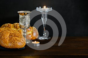 Shabbat Shalom challah bread, shabbat wine and candles on wooden table