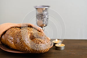 Shabbat Shalom - challah bread, shabbat wine and candles on wooden table