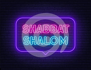 Shabbat Shalom neon sign in the speech bubble on brick wall background.