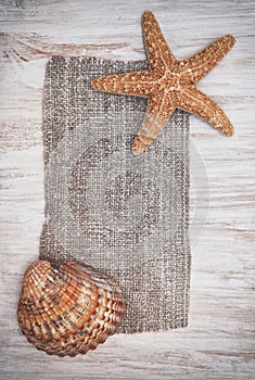 Shabby chic background with seashells and sackcloth