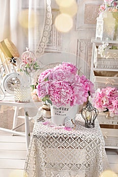 Shabby chic style interior with a bunch of pink peonies on coffee table