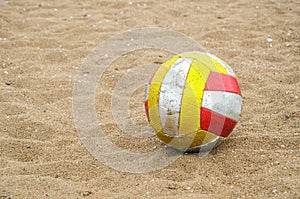 Shabby dirty volleyball on sand. Attribute of beach volleyball, sports games on the coast