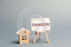 Shabby housing. Inscription Danger. The concept of an emergency house. Old house from which evacuation of residents is required.