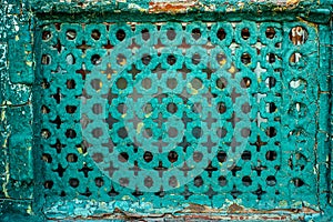 Shabby Iron Old Grille On Emergency Window. Iron Sheet With Different Geometric Holes Painted By Blue Cracked Paint