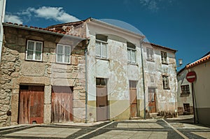 Shabby old houses with wooden doors on empty alley