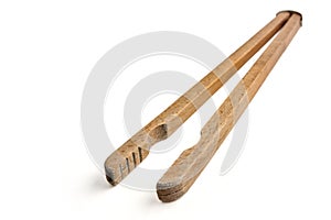 Shabby old wooden tongs for boiling hot washing clothes isolated on white background