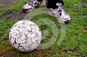 Shabby poor soccer ball and legs