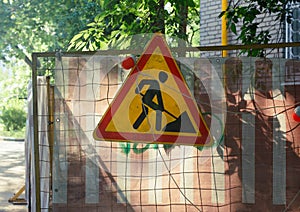 Shabby road sign with digging man. Shot with a backlight