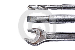 Shabby spanner, chisel and drill closeup on white background