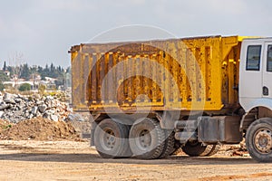 Shabby truck body against the background of the ruins of a wasteland construction site