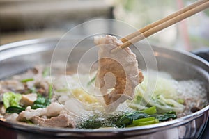 Shabu Shabu or Sukiyaki or hot pot ,Hand holding pork using chopsticks, Japanese food