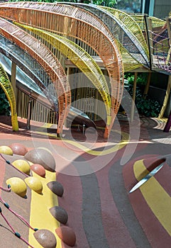 Shaded kid`s playground activity tower equipment at park. Children`s playing area indoor with toys equipment