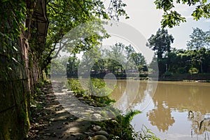 Shaded riverside pathway in sunny autumn