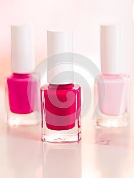 Shades of pink and red nail polish set on glamour background, nailpolish bottles for manicure and pedicure, luxury