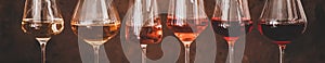 Shades of Rose wine in glasses, rusty background, wide composition