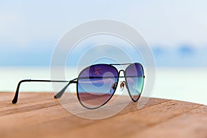 Shades or sunglasses on table at beach