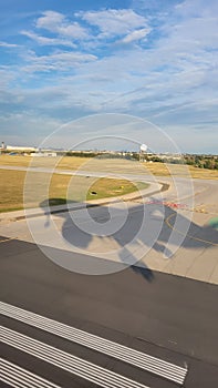 Shadow of 787 airplane on airport runway as it comes in for landing