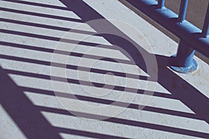 Shadow of the bars of a railing on a street in Madrid, Spain.