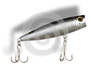 Shadow behind and above a silver artificial fishing lure with treble hooks