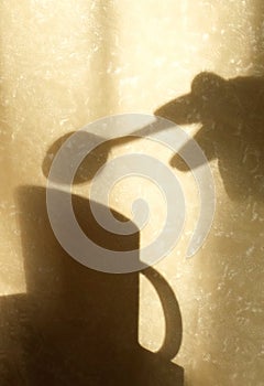 Shadow on beige wall with neutral pattern,  cup  and hand with spoon, wabi sabi aethetics