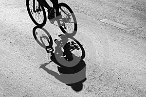 shadow of the bicycle and the cyclist .