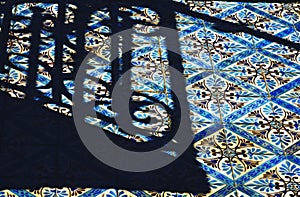 A shadow on a bold blue and gold tiled facade in Lisbon - PORTUGAL