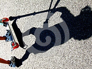 Shadow of a child riding a scooter