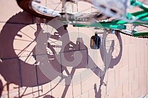 Shadow from children`s bike and spoked wheels on paving stones in the park