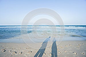 Shadow of couple on the sand at beach with sea