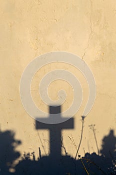 Shadow of a cross on a grave in a Greek cemetery at dawn