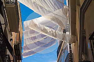 Shadow curtains on the street in Seville, Spain protecting tourists from sun and heat.