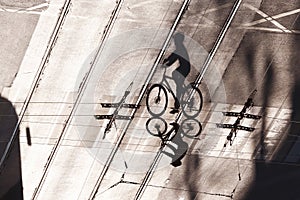Shadow of a cyclist on a road with tram rails