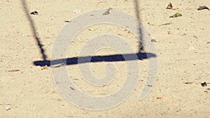 Shadow of empty swing in a playground