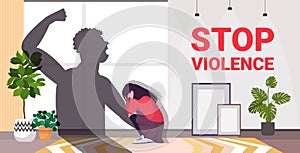 Shadow of furious angry man raised punishment fist over scared woman stop family violence and aggression concept