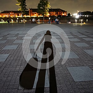 Shadow girl with bag. Night time