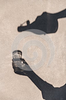 shadow of hands pouring drink from bottle to glass