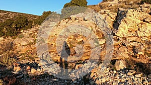 Shadow of hiker against the rocks of Mt Hymettus in Greece, at dusk