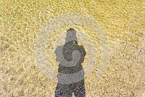 Shadow of human nature water on sand background